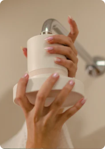 Hands holding the Neena filter on a shower arm